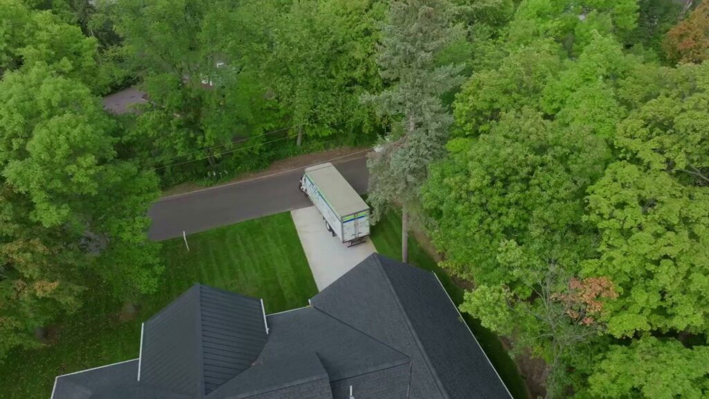 An aerial view of a Goal Line Moving truck driving on a residential street in Maple Grove, MN.