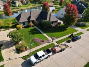An aerial view of a Thompson Acres crew with a truck and lawn care equipment at a residential property in Davenport, IA.