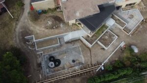 An aerial view of a pool construction site showing excavation and early concrete work by Acapulco Pool and Spa LLC in Los Angeles, CA