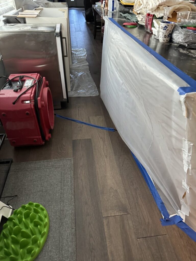 An industrial air mover operating within a plastic containment area, part of the water damage drying process by Standard Restoration in Salt Lake City, UT.