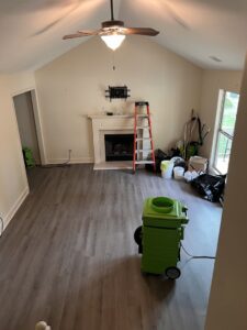An air mover and dehumidifier in a living room for water damage drying by Servpro of Athens, GA.