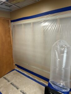 Air mover and dehumidifier in a room with plastic containment for water damage mitigation by Paul Davis of Eastern Ohio in Youngstown, OH.