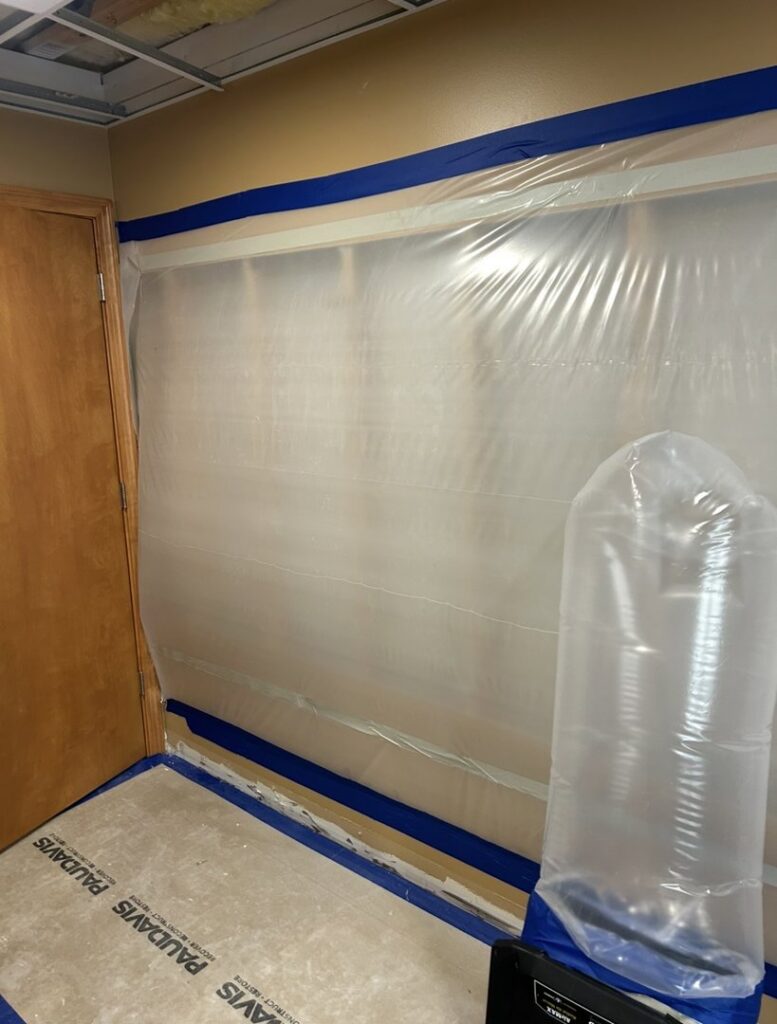 Air mover and dehumidifier in a room with plastic containment for water damage mitigation by Paul Davis of Eastern Ohio in Youngstown, OH.