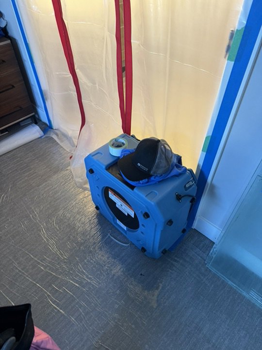 An air mover inside a plastic containment area for water damage drying by Utah Home Restoration in Springville, UT