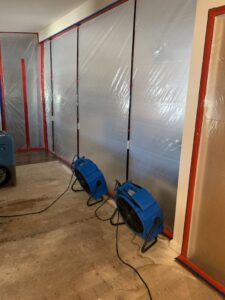 Two air movers and plastic containment sheeting used for water damage drying by Emergency Flood Team in Gilbert, AZ