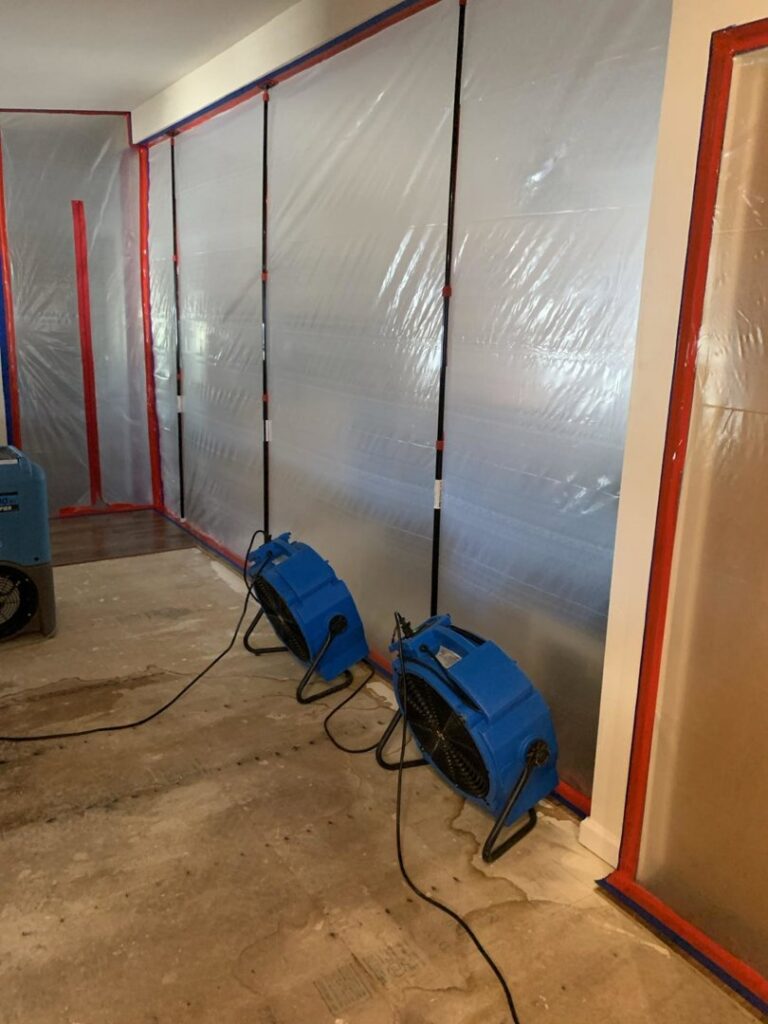 Two air movers and plastic containment sheeting used for water damage drying by Emergency Flood Team in Gilbert, AZ