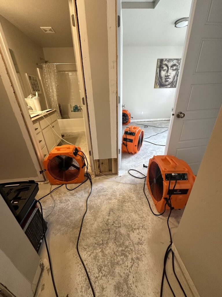 Multiple air movers and dehumidifiers set up in a hallway for water damage drying by Restorex in Petaluma, CA.