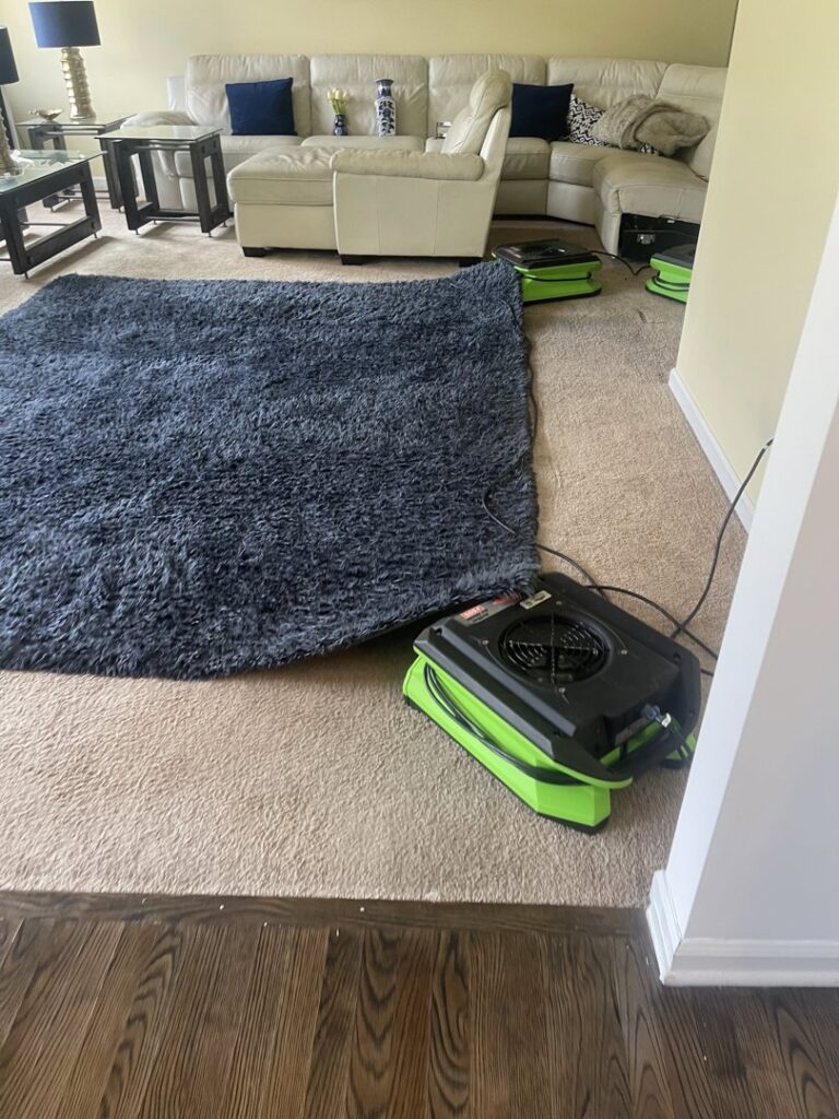 Air movers and fans drying a carpet in a living room after water damage, by Servpro South Jersey City Bayonne in Jersey City, NJ.