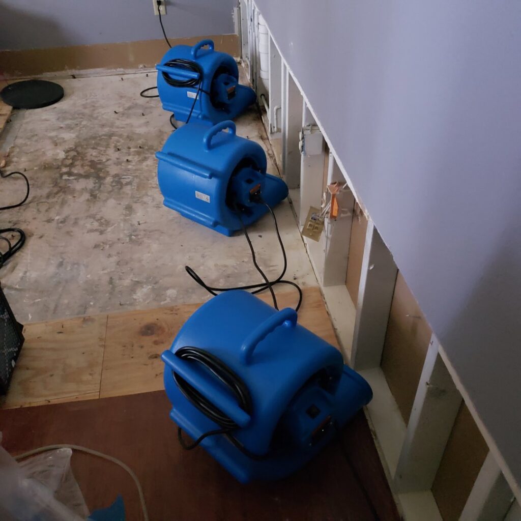Blue air movers drying an exposed subfloor after water damage by Belfor Property Restoration, New Orleans, LA