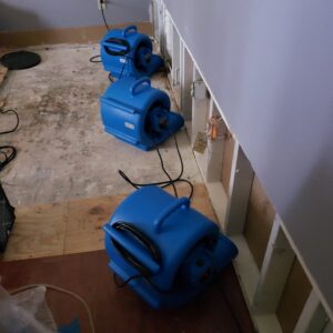Blue air movers drying an exposed subfloor after water damage by Belfor Property Restoration, New Orleans, LA