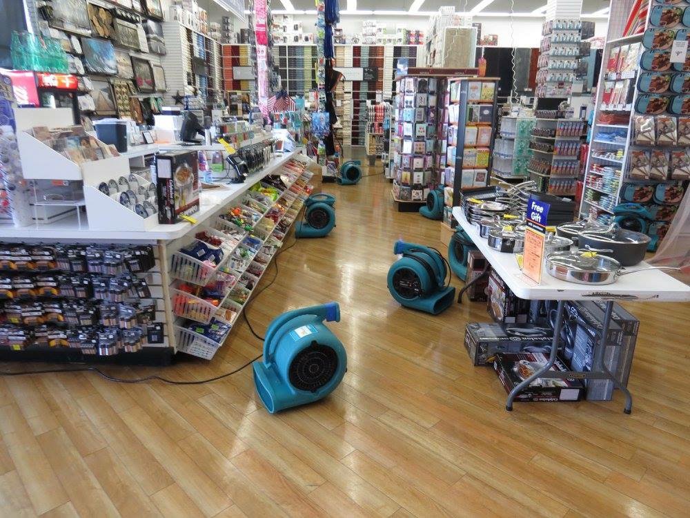 Air movers drying a wooden floor in a retail store after water damage by ServiceMaster of Laredo by Proremediation in Laredo, TX.