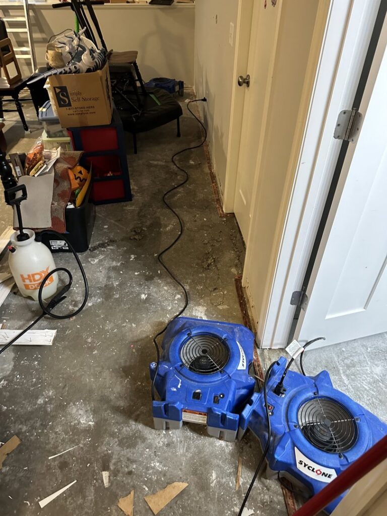 Two air movers drying a hallway floor during water damage restoration by Restoration Alliance Services in Elk River, MN.
