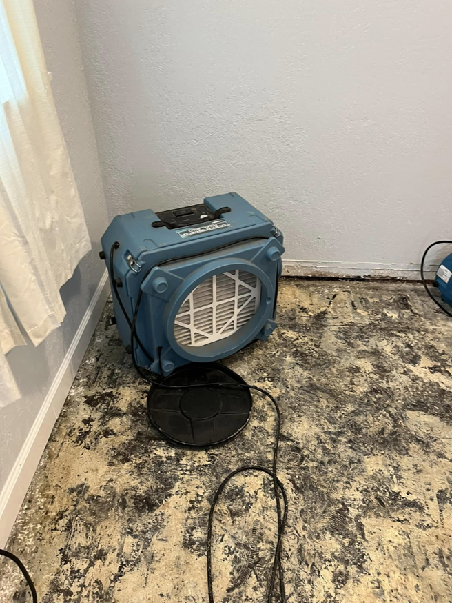 An air scrubber and dehumidifier drying a water-damaged floor at a job site for Highland Restoration in Hampton, VA