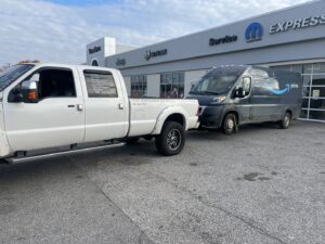 An Amazon Prime delivery van being towed by a white pickup truck, showcasing towing services by Swift Response Road Services, LLC in Memphis, TN.