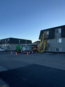 Large yellow drying ducts from Clean Care of New England trailer into an apartment building for water damage in Cranston, RI
