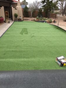 Artificial turf being installed in a residential yard by Green Thumb Lawn Care & Maintenance, LLC in Rio Rancho, NM.