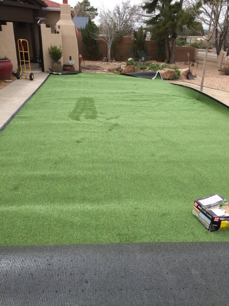 Artificial turf being installed in a residential yard by Green Thumb Lawn Care & Maintenance, LLC in Rio Rancho, NM.