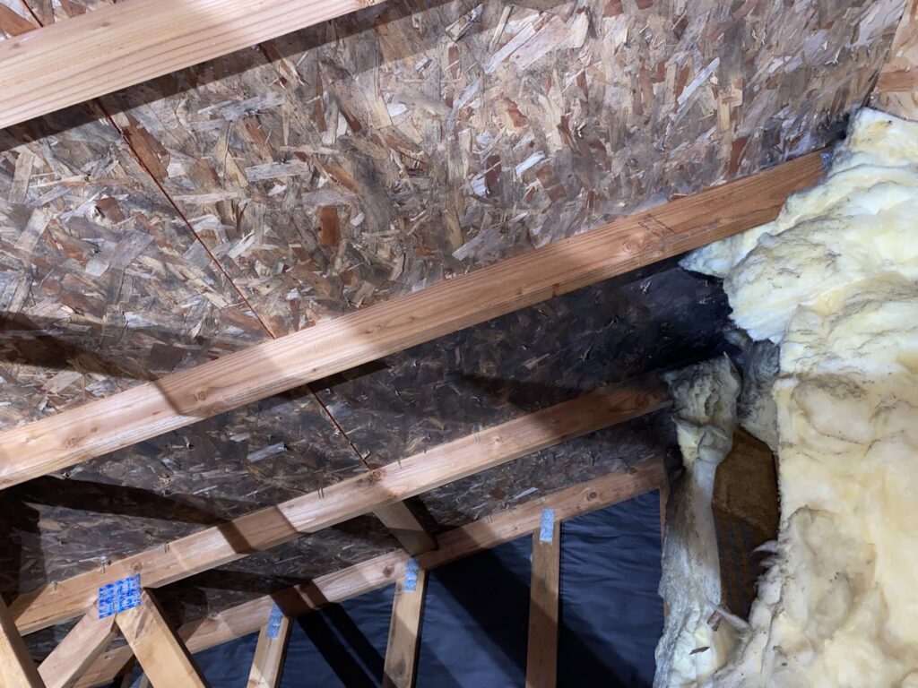 Attic space showing mold and water damage on OSB sheathing and insulation, indicating moisture issues, remediated by Quality Remediation llc in Everett, WA.
