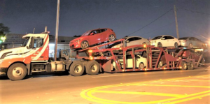 A large auto transport car carrier truck from Ted & Stan's Towing Service transporting multiple vehicles in Cutler Bay, FL.