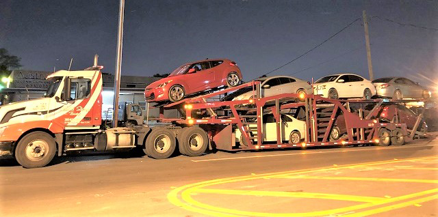 A large auto transport car carrier truck from Ted & Stan's Towing Service transporting multiple vehicles in Cutler Bay, FL.
