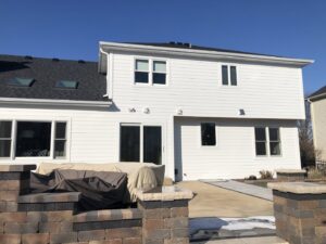 The back of a house with new white siding and windows installed by SmardBuild Siding and Exteriors in Naperville, IL