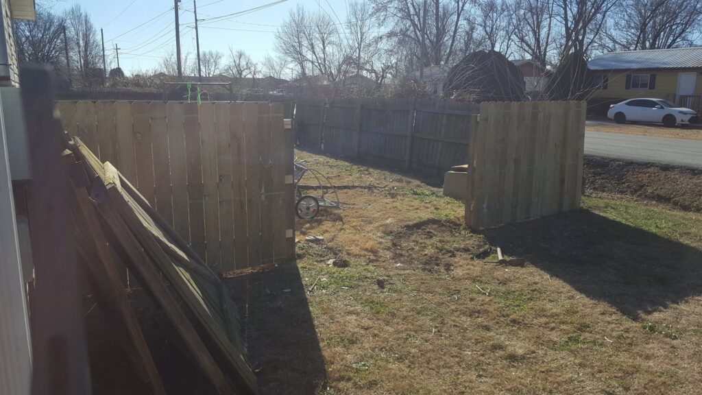 A new wooden fence being installed in a backyard, a service provided by Full Throttle landscapes and lawn care in Port Orchard, WA.