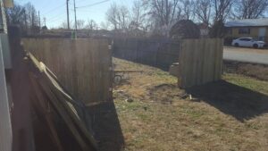 A new wooden fence being installed in a backyard, a service provided by Full Throttle landscapes and lawn care in Port Orchard, WA.