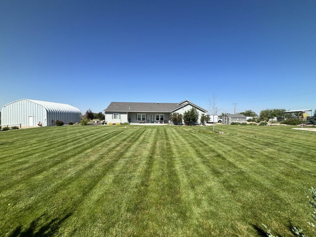 A beautifully striped backyard lawn, showcasing the meticulous work of Luna's Lawn Care LLC in West Des Moines, IA.