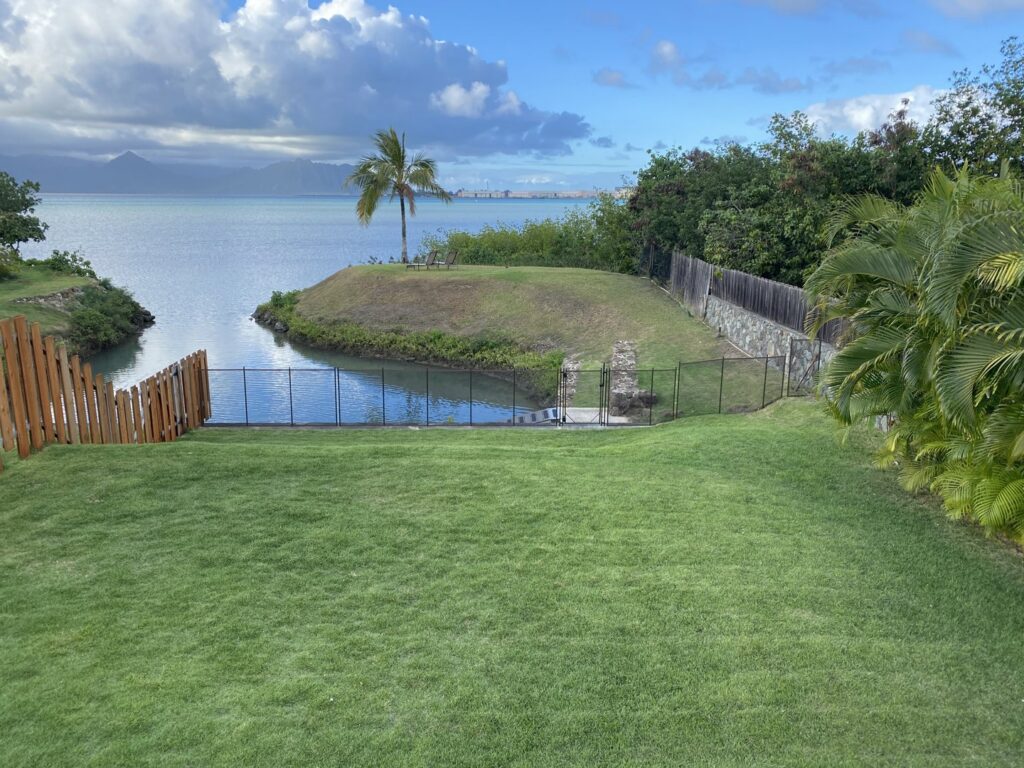 A backyard waterfront safety fence installed by Guardian Pool Fence Systems of Hawaii, securing a property near the bay in Honolulu, HI.