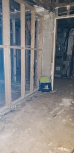A basement room with exposed studs and concrete floor during water damage remediation by GOD'S GLORY LLC in Bowie, MD.