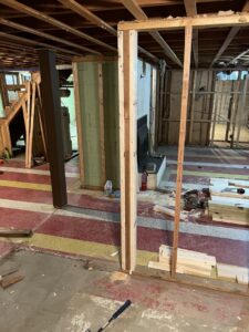 A basement undergoing demolition and water damage repair, showing exposed framing and a partially removed floor, by UpKeep Properties, LLC in Elizabethtown, KY.