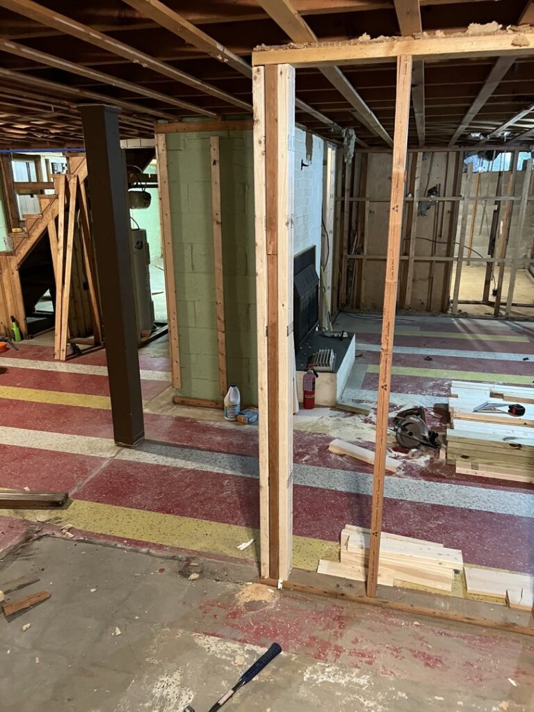 A basement undergoing demolition and water damage repair, showing exposed framing and a partially removed floor, by UpKeep Properties, LLC in Elizabethtown, KY.