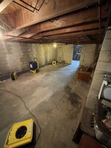 A basement with drying equipment, including air movers and dehumidifiers, set up by 1-800 Water Damage of Harrisburg, PA in York, PA.