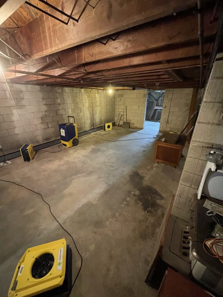 A basement with drying equipment, including air movers and dehumidifiers, set up by 1-800 Water Damage of Harrisburg, PA in York, PA.