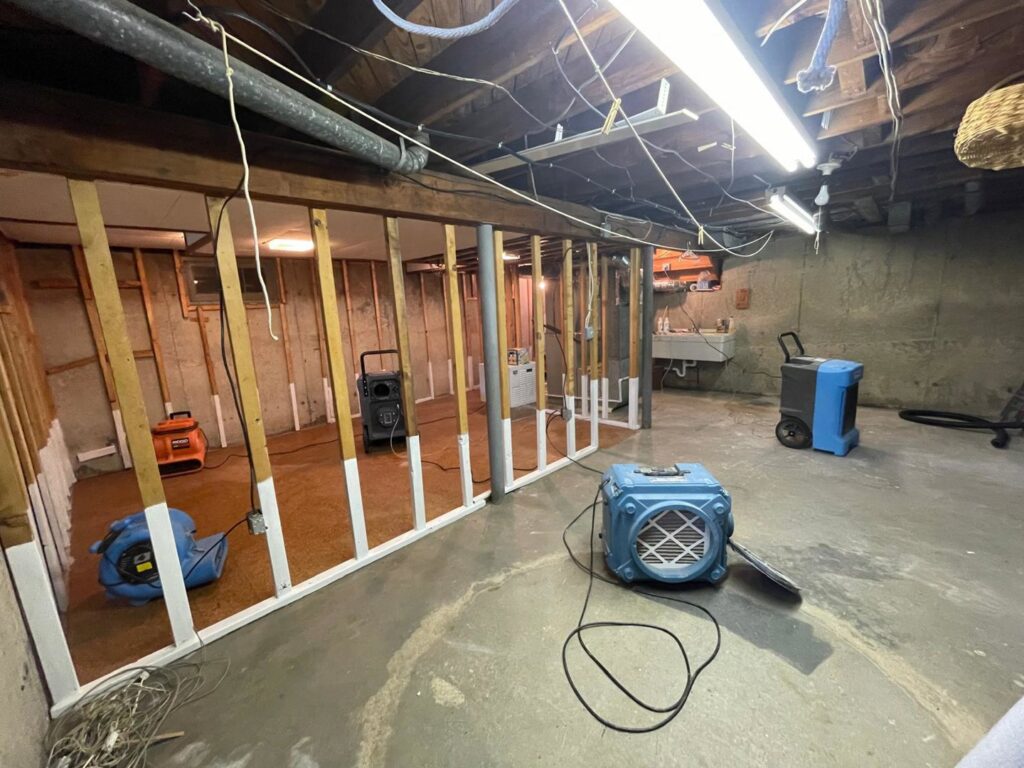A basement undergoing water damage drying with multiple air movers and dehumidifiers by Mold Master Restoration in Jersey City, NJ