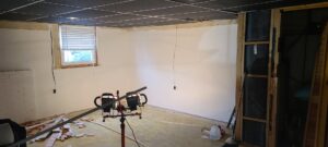 A basement undergoing restoration with new white walls and exposed studs after water damage remediation by 1d Remedy LLC in Mechanicsburg, PA