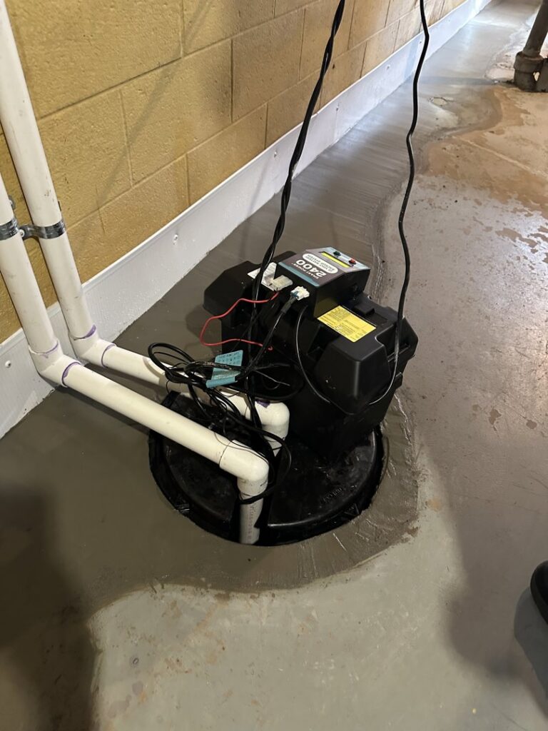 A basement sump pump installation with water on the floor by EverDry Toledo in Toledo, OH.