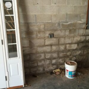 A basement wall showing visible water stains and efflorescence, indicating water damage, before repair by Stay Dry Waterproofing LLC in Marysville, OH.