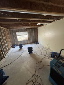 A basement undergoing extensive water damage demolition and drying with multiple air movers by Utah Flood Guys in Sandy, UT.