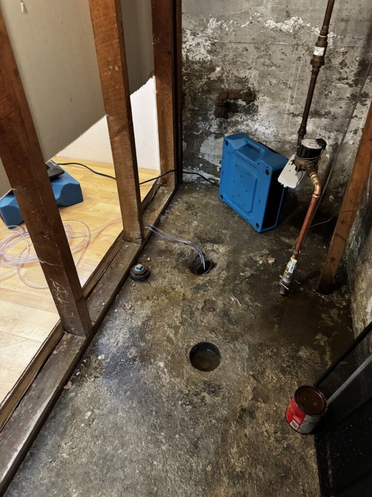 A basement undergoing water damage remediation with exposed studs and drying equipment from RestoPros in Bangor, ME.
