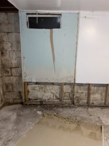 Basement wall with extensive water damage, mold growth, and removed drywall by Acclaim Restoration in Harrisburg, PA
