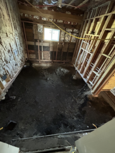 A basement undergoing water damage remediation with exposed earth and framing by HomeTown Construction and Restoration LLC in Anaconda, MT