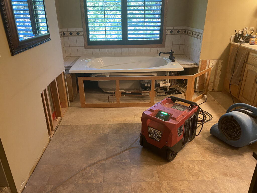 A basement undergoing water damage remediation with exposed studs and insulation by Minneapolis Water Damage Specialist 24/7 in Minneapolis, MN.
