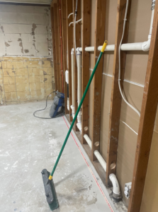 A basement undergoing water damage restoration with exposed studs and drying equipment from USA Water Damage Thunder Restoration in Coon Rapids, MN.