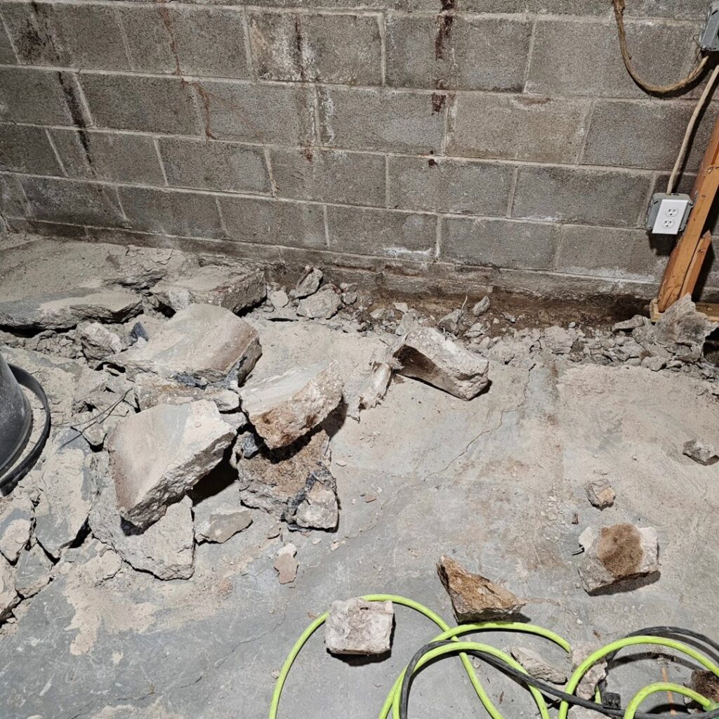 Concrete debris on a basement floor, showing preparation for waterproofing by EverDry Toledo in Toledo, OH.