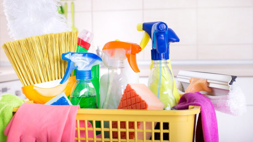A yellow basket filled with cleaning supplies like spray bottles, sponges, and gloves, for Absolute Cleaning Service in Salisbury, MD.