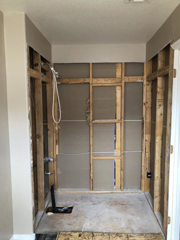 A bathroom area with walls removed, exposing studs, indicating demolition for water damage restoration by Lotus Restoration Services in Gilbert, AZ.