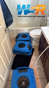 Water damage drying equipment set up in a bathroom by Western Skies Restoration in Gilbert, AZ.