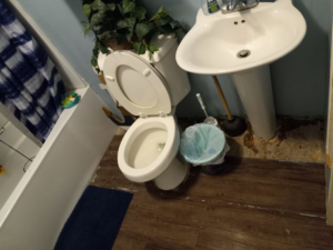 An overview of a bathroom with a toilet, sink, and bathtub, showing an area ready for cleaning by J & A Cleaning and more in Norfolk, NE.