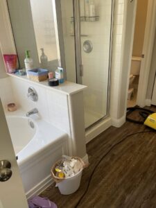 A bathroom with a clean tub and shower, with a vacuum cleaner on the floor, by Picky Performance Cleaning in North Las Vegas, NV